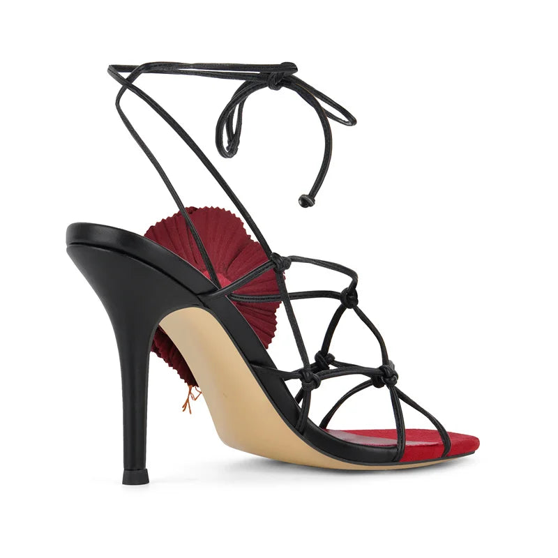 Side view of stiletto lace-up sandals with floral accent