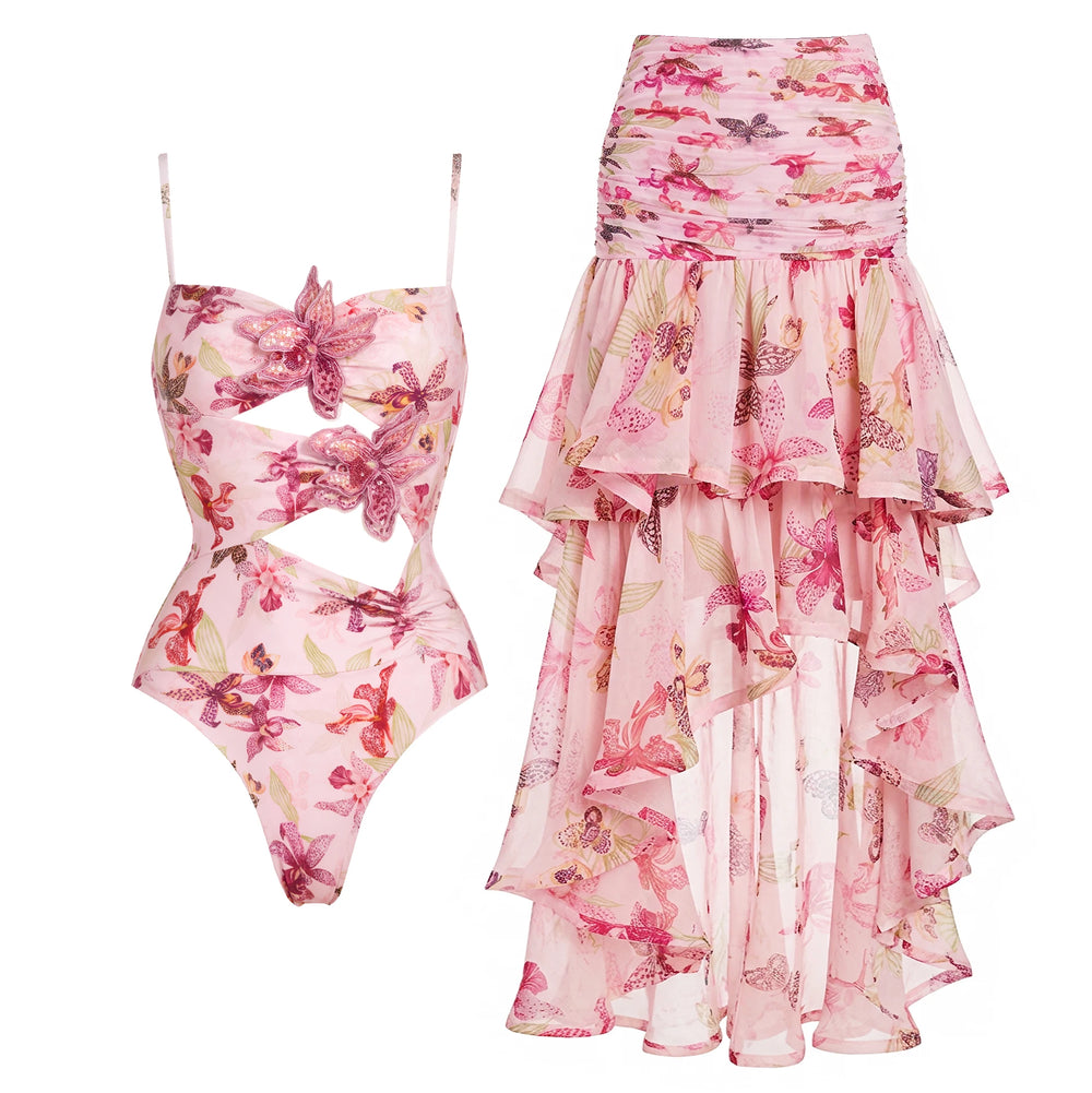 Pink floral print one-piece swimsuit with cut-outs and embellished flowers, paired with a high-low ruffled skirt.