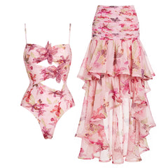 Pink floral print one-piece swimsuit with cut-outs and embellished flowers, paired with a high-low ruffled skirt.