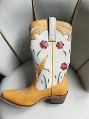 Pointed toe embroidered floral western boots in yellow.