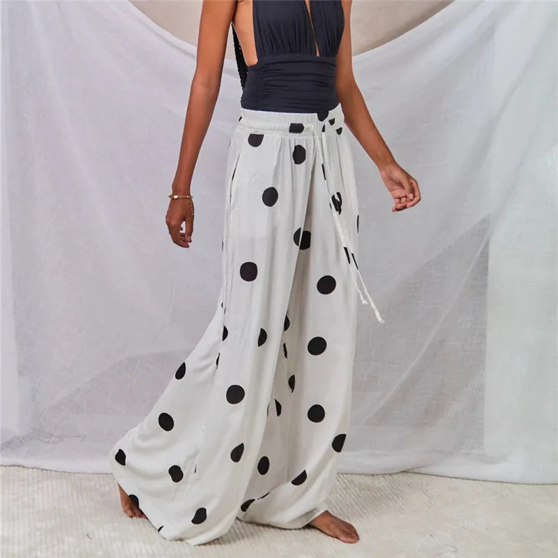 Model in motion wearing white polka dot wide leg palazzo pants