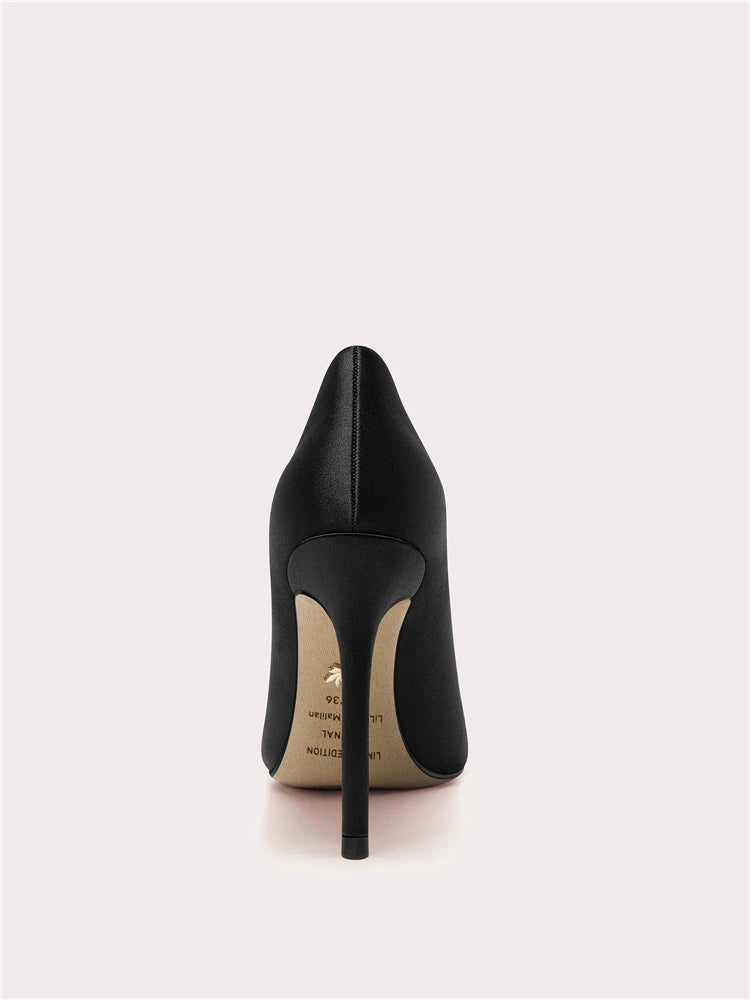 Black high-heeled shoe on a light gray background