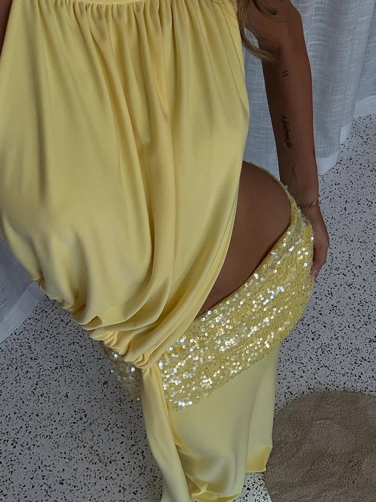 Yellow dress with a sequin bottom section on a speckled floor.