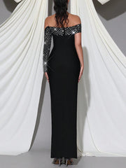 Black evening gown with long sleeves and sequin details on a white draped background