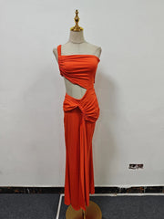 Orange evening gown on a mannequin against a white wall.