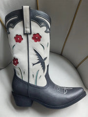 Decorative cowboy boot with floral patterns on a light background