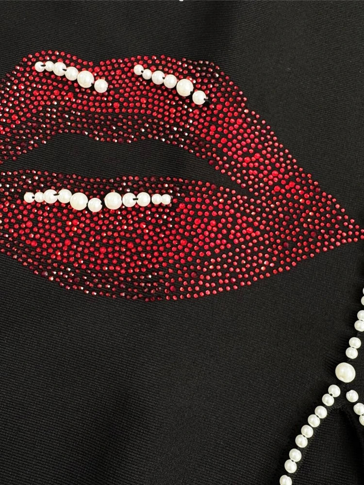 Black garment with red lip design and pearl details