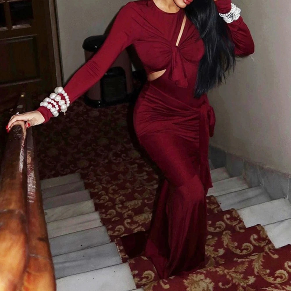Woman in a red dress standing on a staircase with a decorative carpet.
