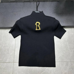 Black turtleneck sweater with a gold keyhole design on a gray background