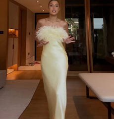 Woman in a white evening gown with feathered top in an indoor setting