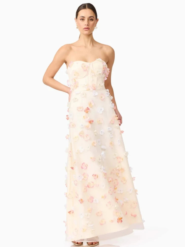 Woman wearing a strapless floral gown on a white background