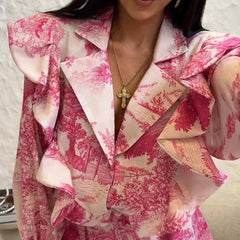 Person wearing a pink and white floral patterned outfit with a necklace.