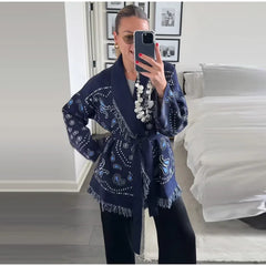 Woman wearing a blue patterned scarf in a bedroom setting