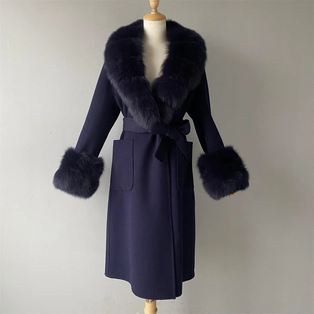 Navy blue coat with fur trim on a mannequin against a plain background