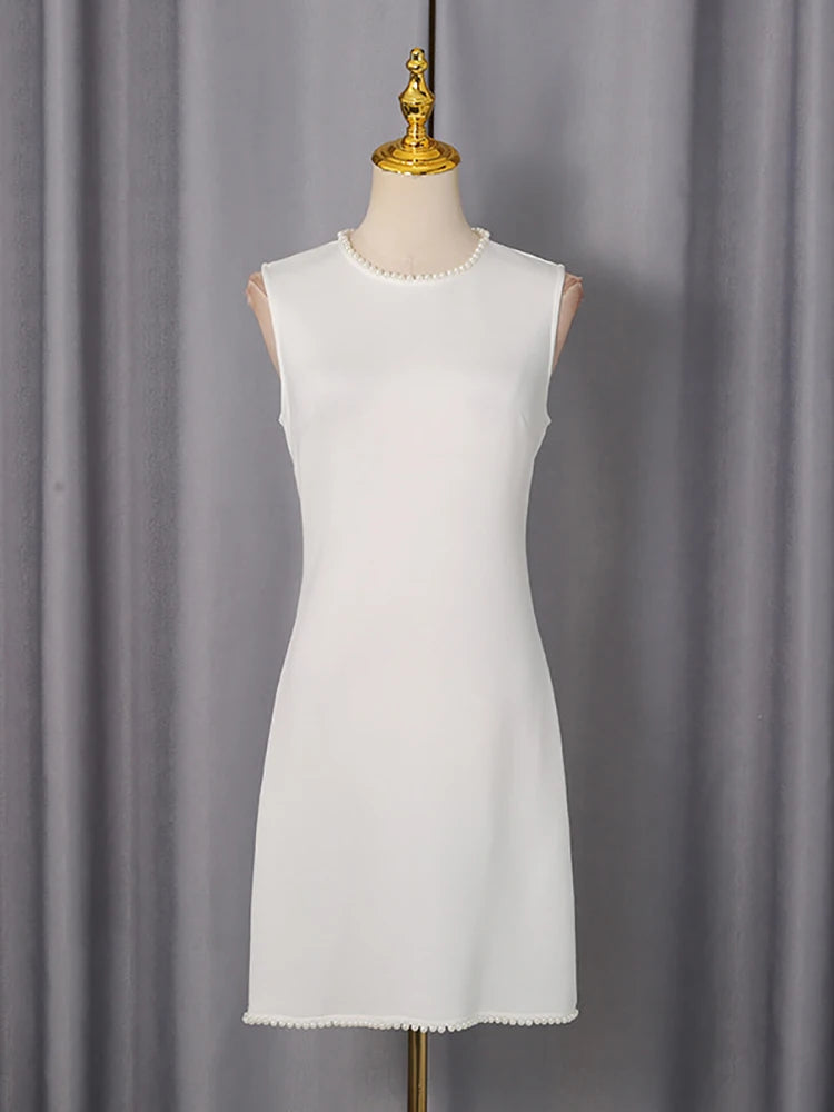 White sleeveless dress on a mannequin against a gray curtain background