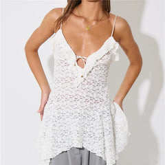 Woman wearing a white lace top with thin straps on a plain background