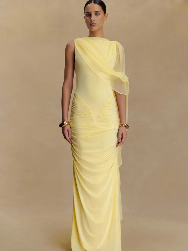 Woman wearing a yellow saree with a plain background