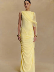 Woman wearing a yellow saree with a plain background