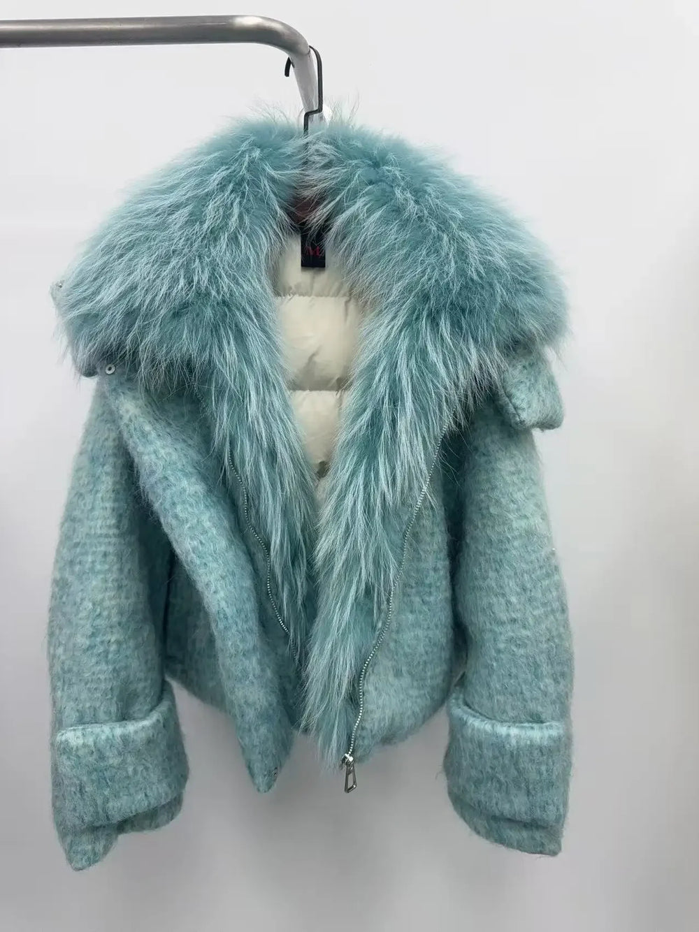 Teal coat with fur collar on a white background