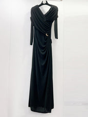 Black evening gown on a hanger against a white background