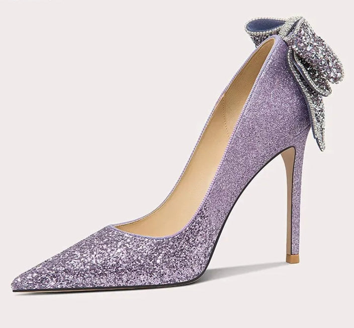 Purple high-heeled shoe with a decorative bow on a white background