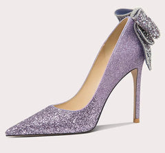 Purple high-heeled shoe with a decorative bow on a white background