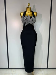 Black evening gown with silver embellishments on a mannequin against a white background