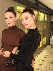 Two women posing together in a stylish indoor setting.