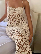 Person wearing a beige crochet dress sitting on a white couch.
