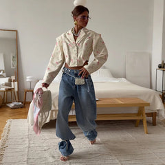 Woman in a stylish outfit standing in a bedroom