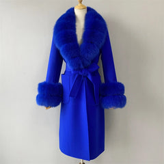 Blue coat with fur trim on a mannequin against a plain background