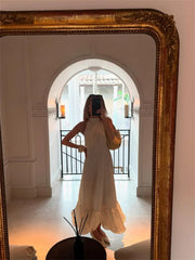 Person taking a mirror selfie wearing a long dress in a room with a large ornate mirror.