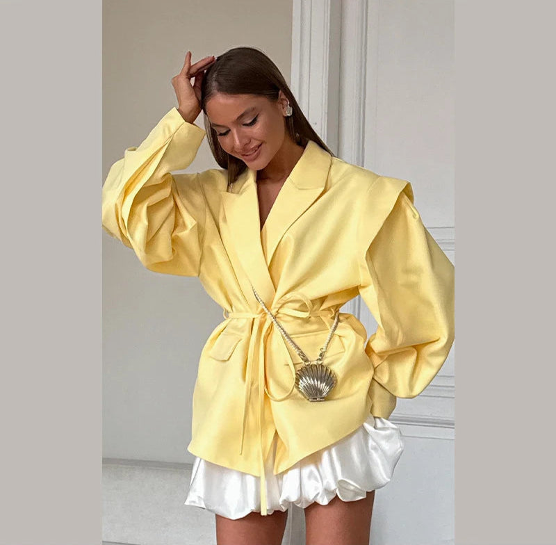 Woman wearing a yellow blazer and white skirt indoors