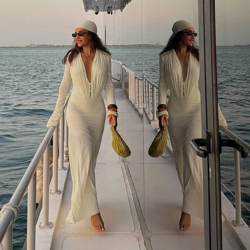 Woman in a white outfit standing on a boat deck with water in the background