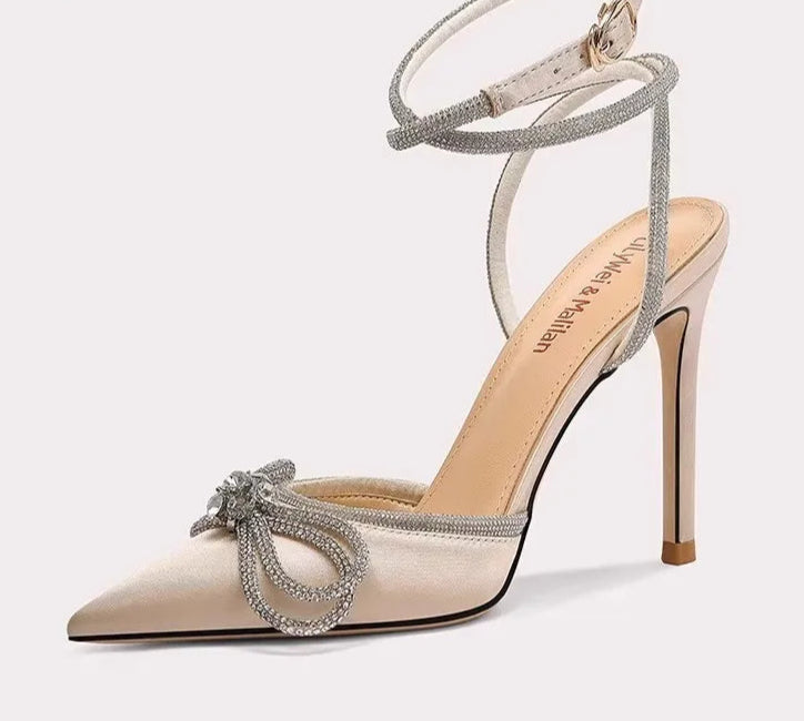 High-heeled shoe with decorative strap on a white background