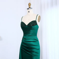 Green evening gown on a mannequin against a white background