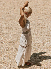 Woman in a white dress standing on a textured beige surface