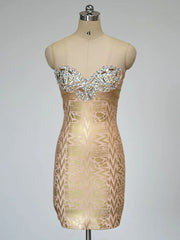 Beige strapless dress with intricate pattern on a mannequin against a gray background