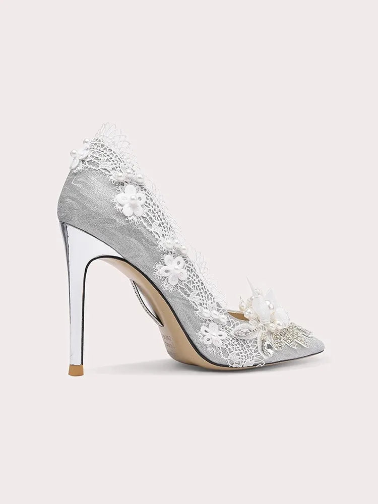 Silver high-heeled shoe with floral lace design on a white background