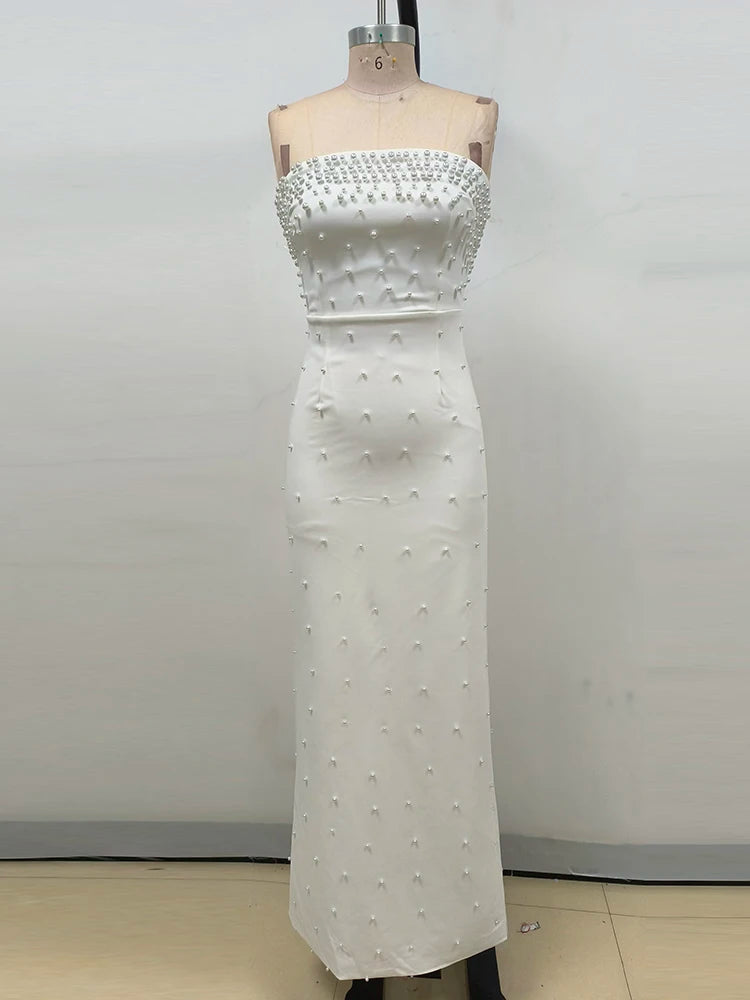 White strapless dress with bead detailing on a mannequin against a plain background
