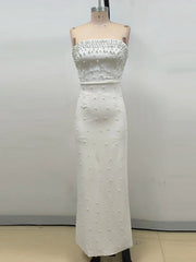White strapless dress with bead detailing on a mannequin against a plain background