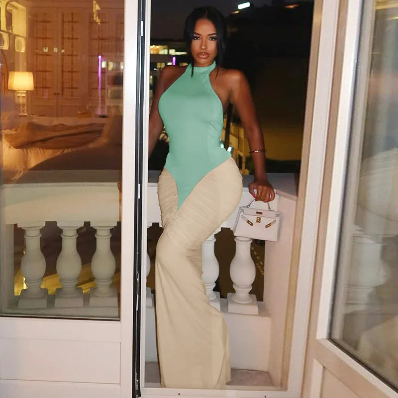 Woman in a green top and beige pants standing in a doorway.
