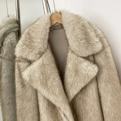 Beige fur coat on a hanger against a neutral background