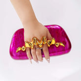 Sculptural wave handle clutch bag with pink acrylic exterior