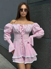 Woman wearing a pink off-shoulder outfit with puffed sleeves against a dark background