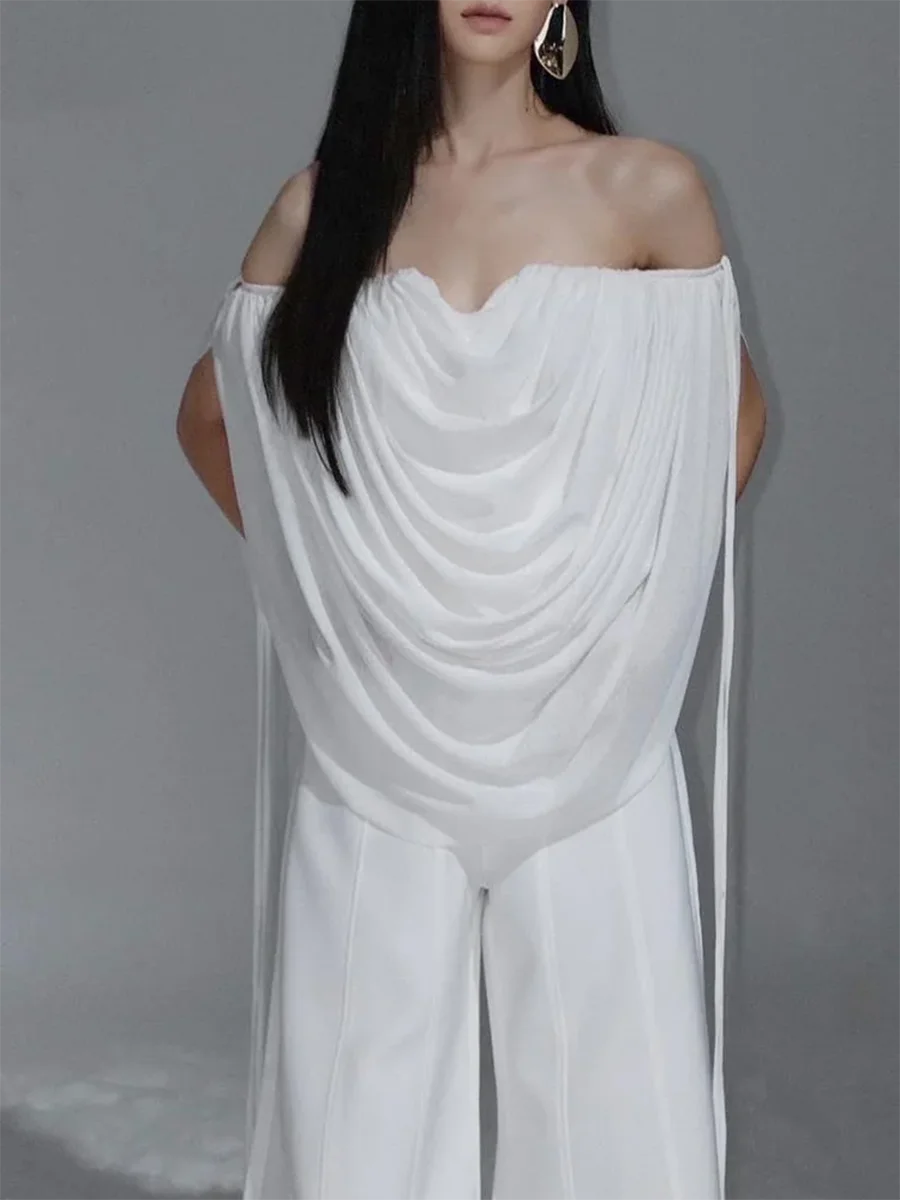 Woman wearing a white off-shoulder dress against a gray background