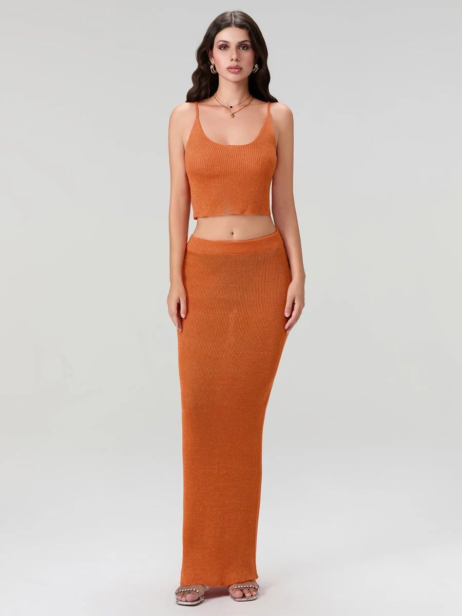 Woman wearing an orange top and long skirt set on a white background