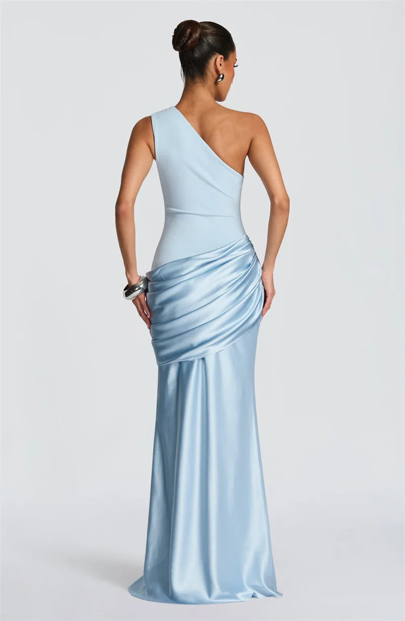 Woman wearing a light blue one-shoulder evening gown on a white background