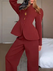 Person wearing a red suit standing in a room with a bed in the background