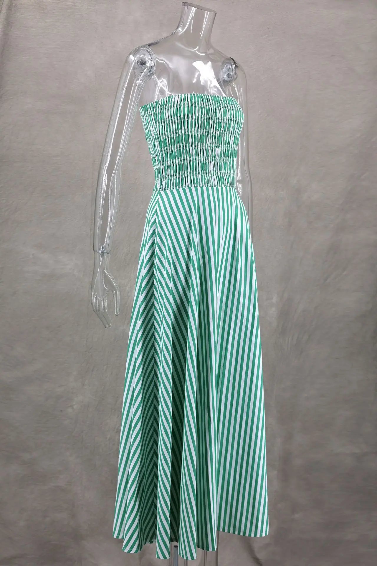 Green and white striped dress on a mannequin against a gray background